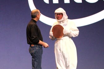 Der verstorbene Apple-Mitgründer Steve Jobs nimmt von einem Intel-Mitarbeiter symbolisch einen Chip entgegen: Die langjährige Zusammenarbeit der beiden Konzerne könnte bald enden.