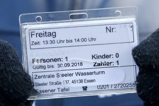 Eine Kundin der Essener Tafel zeigt ihre Berechtigungskarte.