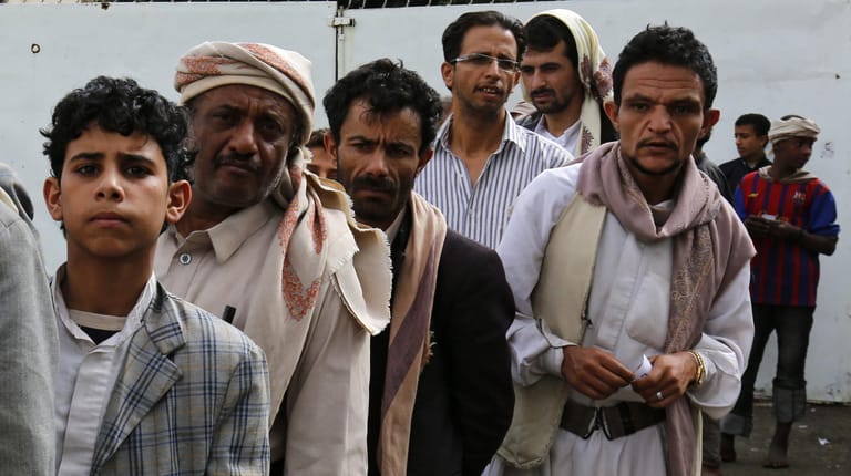 Männer warten in der Hauptstadt Sanaa auf Essenslieferungen (2016): Millionen Menschen im Jemen hungern. Internationale Geldgeber wie Deutschland stellen viel Geld zur Verfügung – aber nicht genug.