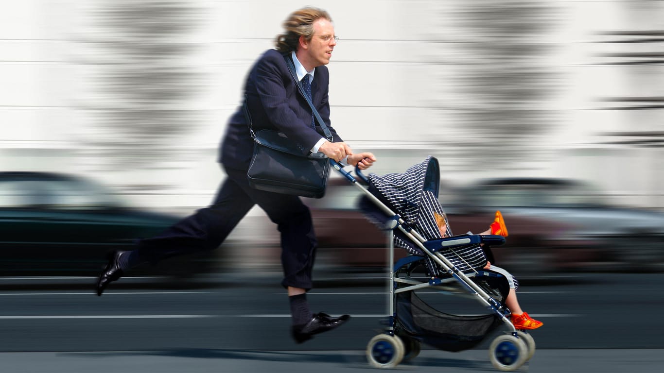 Geschäftsmann rennt mit Kinderwagen.