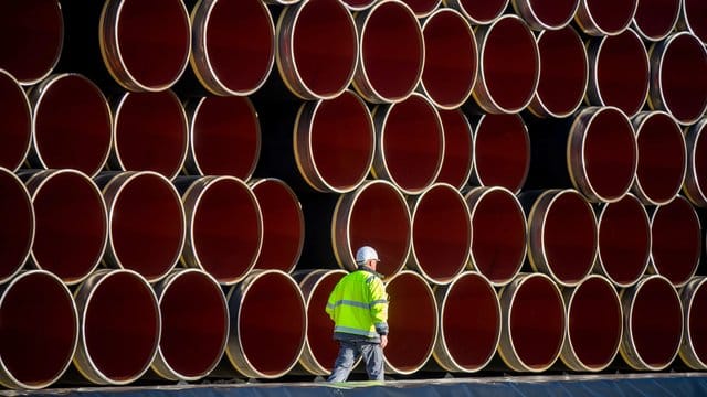 Ein Arbeiter geht im Hafen von Sassnitz-Mukran an tonnenschweren Rohren für die zukünftige Ostsee-Erdgastrasse Nord Stream 2 vorbei.