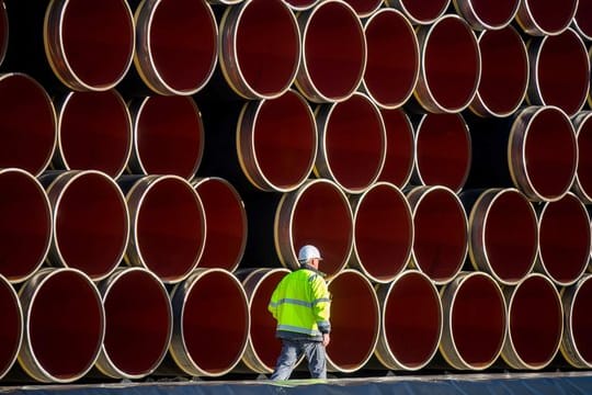 Ein Arbeiter geht im Hafen von Sassnitz-Mukran an tonnenschweren Rohren für die zukünftige Ostsee-Erdgastrasse Nord Stream 2 vorbei.