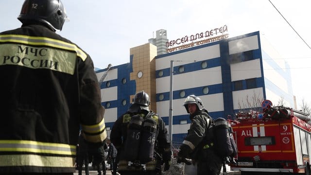 Feuerwehrleute stehen vor dem Einkaufszentrum "Persej dlja detej" (Perseus für Kinder), in dem ein Feuer ausgebrochen ist. Feuerwehrleute stehen vor dem Einkaufszentrum "Persej dlja detej" (Perseus für Kinder), in dem ein Feuer ausgebrochen ist.