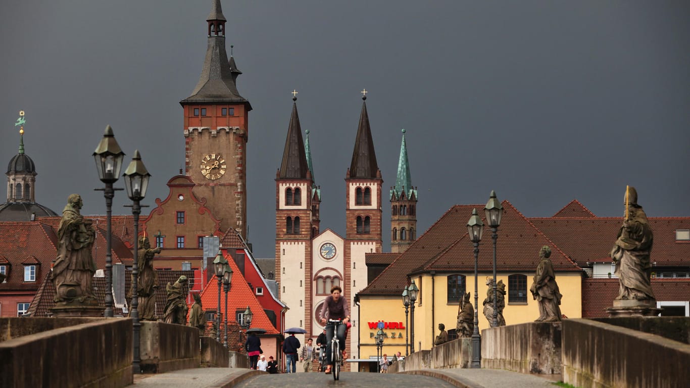 Die Türme der Würzburger Innenstadt ragen in den dunklen Himmel: In Würzburg ist ein psychisch kranker Mann mit einem gestohlenen Laster durch die Innenstadt gerast und hat vier Menschen verletzt. (Archivbild)