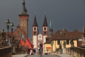 Die Türme der Würzburger Innenstadt ragen in den dunklen Himmel: In Würzburg ist ein psychisch kranker Mann mit einem gestohlenen Laster durch die Innenstadt gerast und hat vier Menschen verletzt. (Archivbild)