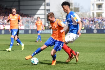 2. Bundesliga: Darmstadts Tobias Kempe (l) und Holstein Kiels Aaron Seydel kämpfen um den Ball.