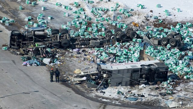 Helfer stehen neben Trümmern und den zwei Fahrzeugwracks am Unfallort, an dem bei einem Busunglück zahlreiche Menschen ums Leben gekommen sind. Helfer stehen neben Trümmern und den zwei Fahrzeugwracks am Unfallort, an dem bei einem Busunglück zahlreiche Menschen ums Leben gekommen sind.