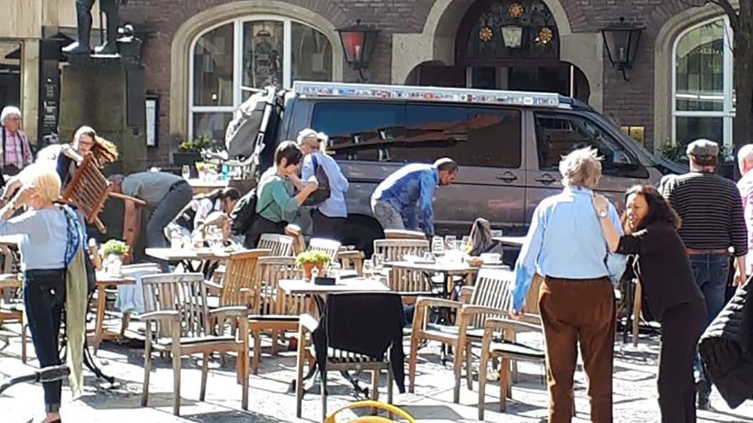 Menschen stehen vor dem Gasthaus Kiepenkerl, kurz nachdem das Fahrzeug in das Straßencafe gefahren ist.