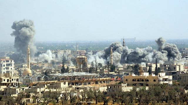 Rauch steigt nach dem Einschlag einer Rakete der syrischen Armee über Duma auf.