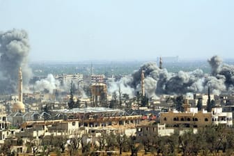 Rauch steigt nach dem Einschlag einer Rakete der syrischen Armee über Duma auf.