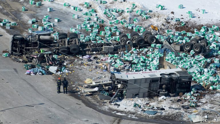Der Ort des Busunglücks in Kanada: Helfer stehen neben Trümmern und den zwei Fahrzeugwracks.