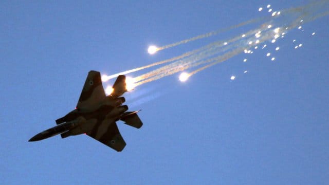 Eine israelische F-15 schützt sich mit Leuchtkugeln vor hitzesuchenden Bodenraketen.