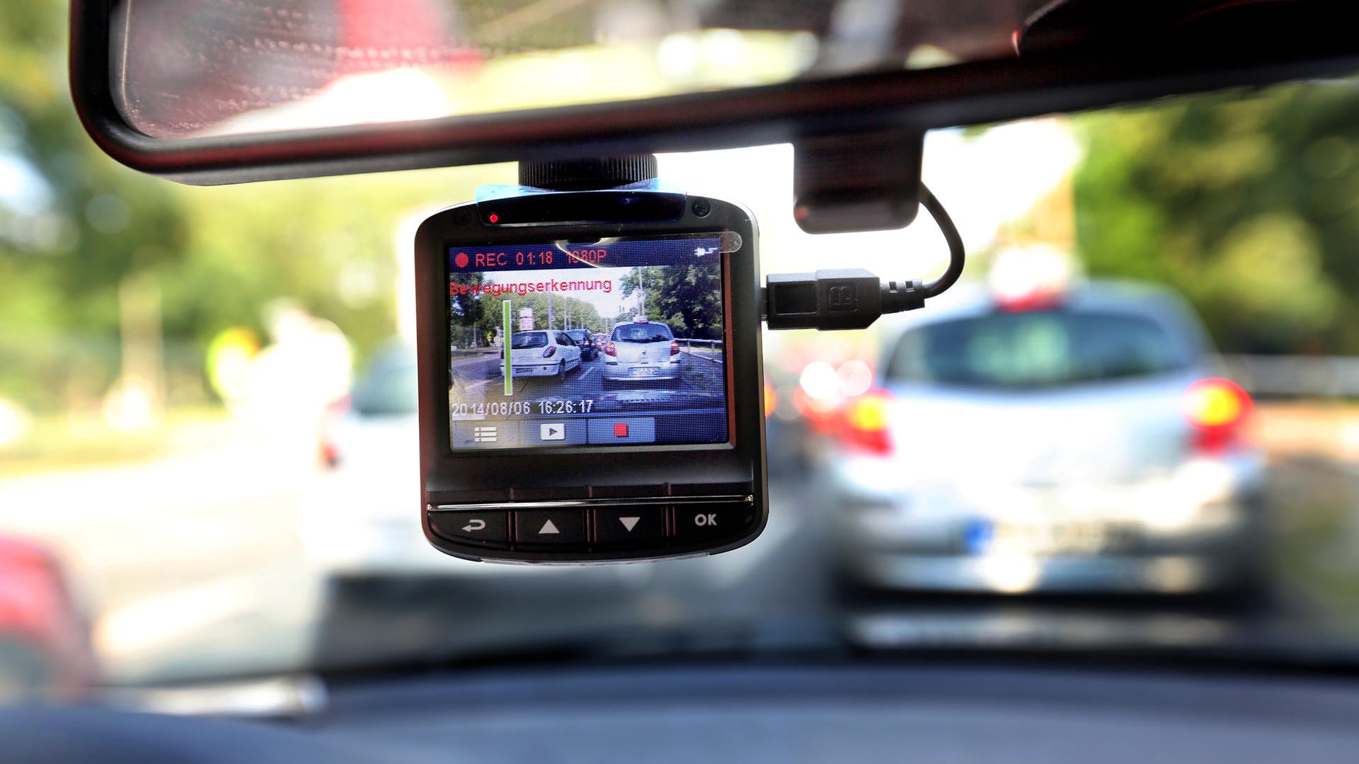 Eine Dashcam, befestigt an einer Windschutzschreibe: Die kleine Kamera filmt den Straßenverkehr aus dem Auto. Eine Dashcam, befestigt an einer Windschutzschreibe: Die kleine Kamera filmt den Straßenverkehr aus dem Auto.
