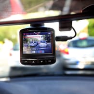 Eine Dashcam, befestigt an einer Windschutzschreibe: Die kleine Kamera filmt den Straßenverkehr aus dem Auto.