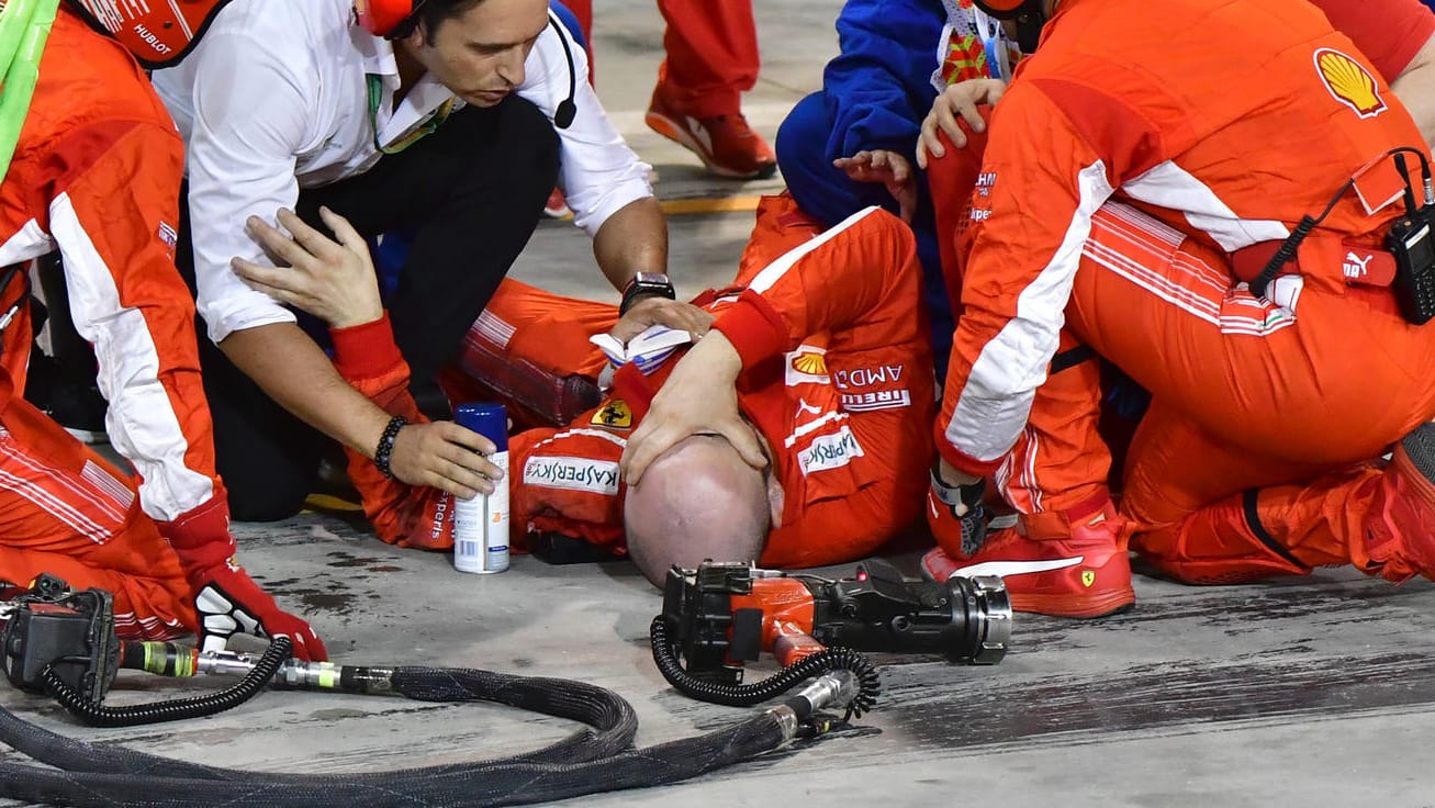 Große Schmerzen bei Francesco Cigarini: Der schwer verletzte Ferrari-Mechaniker wird von seinen Teamkollegen betreut.