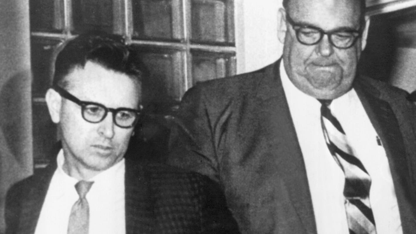 James Earl Ray wird von einem Polizeibeamten abgeführt. Er hatte den Mord an Martin Luther King gestanden und wurde zu 99 Jahren Gefängnis verurteilt.