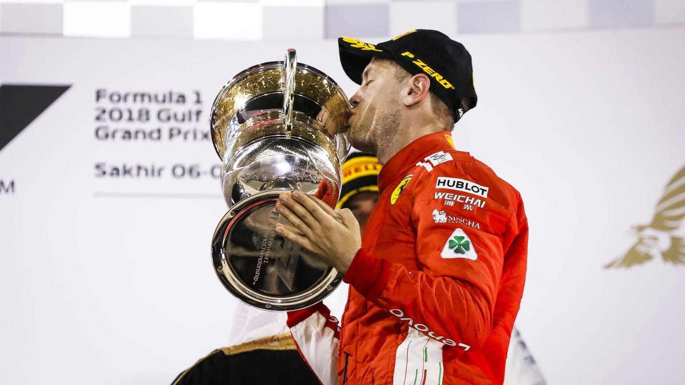 Triumph in Bahrain: Sebastian Vettel küsst den Siegerpokal und lässt die Ferrari-Fans vom WM-Titel träumen.
