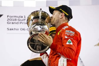 Triumph in Bahrain: Sebastian Vettel küsst den Siegerpokal und lässt die Ferrari-Fans vom WM-Titel träumen.