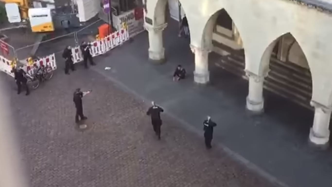 Umstellt: Die Kontrolle von zwei Männern am Historischen Rathaus von Münster. Die Szene ist aus einem Video, das mit irreführenden Angaben in sozialen Medien Verwirrung stiftet.
