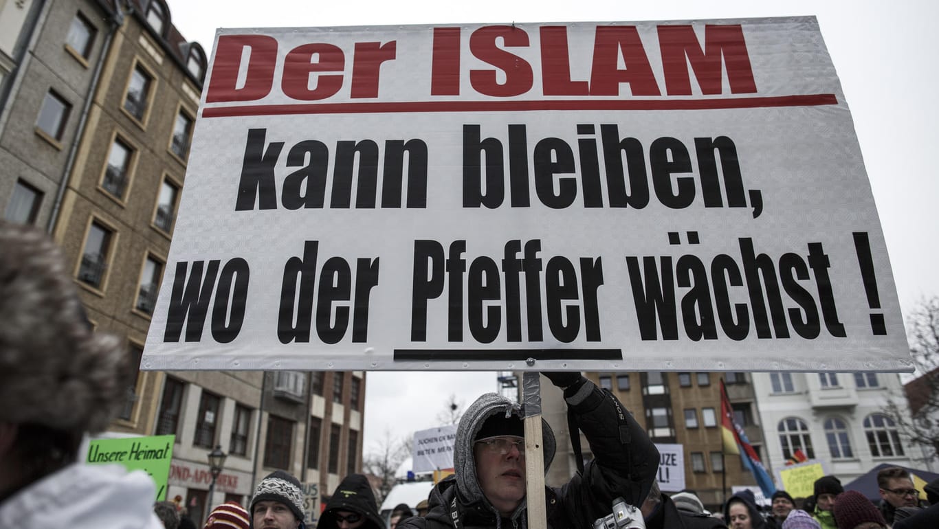 Teilnehmer der Demonstration des Bürgervereins "Zukunft Heimat" gegen Flüchtlinge tragen ein Transparent mit der Aufschrift "Der Islam kann bleiben, wo der Pfeffer wächst !": Erneut Auseinandersetzungen zwischen Deutschen und Ausländern in Cottbus.