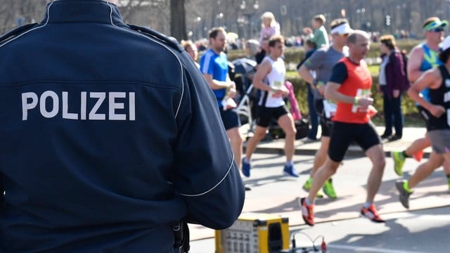 Berliner Halbmarathon: Ein Polizeibeamter steht an der Laufstrecke. Berliner Halbmarathon: Ein Polizeibeamter steht an der Laufstrecke.