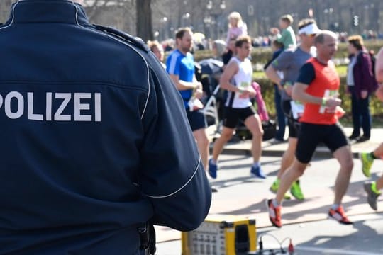 Berliner Halbmarathon: Ein Polizeibeamter steht an der Laufstrecke.
