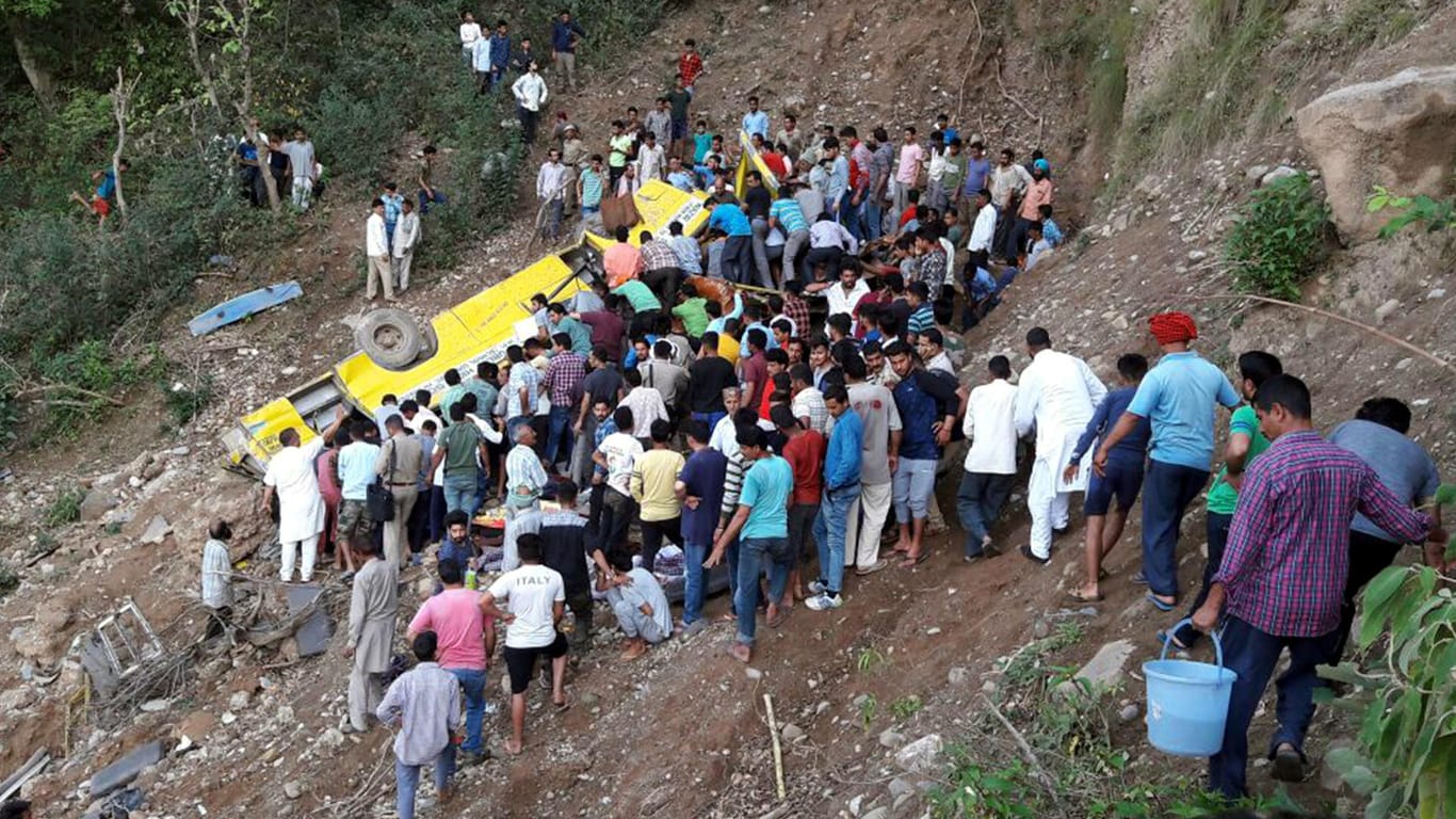 Ein mit Schulkindern besetzter Bus liegt am Hang in der Nähe einer Gebirgsstraße: Mindestens 23 Kinder im Alter von sechs bis elf Jahren seien bei dem Unfall im Bezirk Kangra im westlichen Teil des Himalaya ums Leben gekommen.