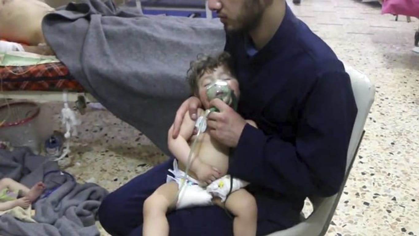 Dieses vom Syrischen Zivilschutz zur Verfügung gestellte Videostandbild zeigt einen Sanitäter, der ein Kleinkind medizinisch versorgt.
