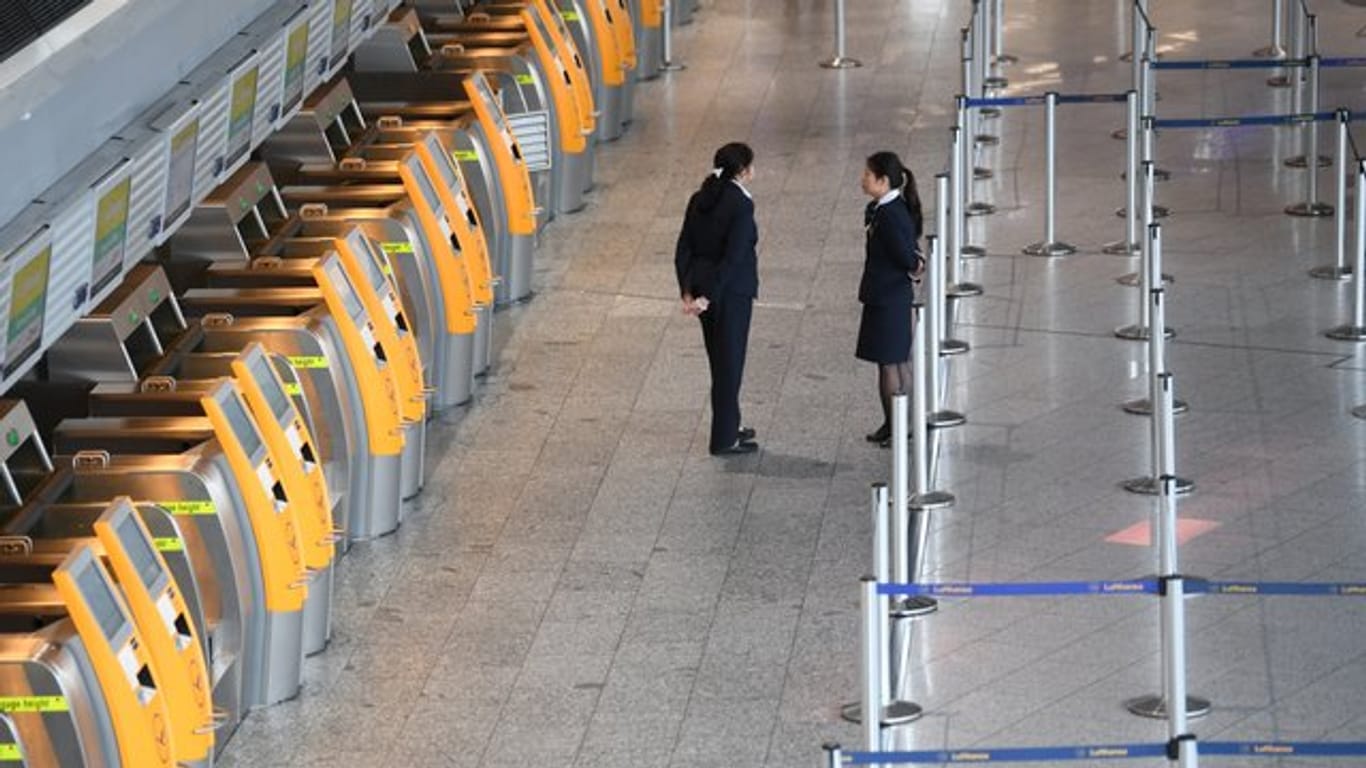 Menschenleer: Lufthansa-Mitarbeiterinnen stehen im Terminal 1 des Frankfurter Flughafens vor verwaisten Check-In-Terminals.