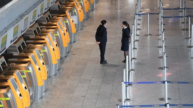 Menschenleer: Lufthansa-Mitarbeiterinnen stehen im Terminal 1 des Frankfurter Flughafens vor verwaisten Check-In-Terminals. Menschenleer: Lufthansa-Mitarbeiterinnen stehen im Terminal 1 des Frankfurter Flughafens vor verwaisten Check-In-Terminals.