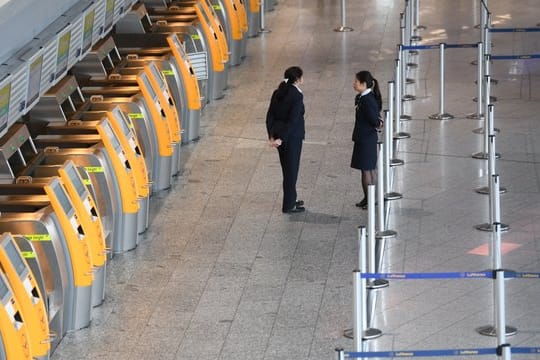 Menschenleer: Lufthansa-Mitarbeiterinnen stehen im Terminal 1 des Frankfurter Flughafens vor verwaisten Check-In-Terminals.