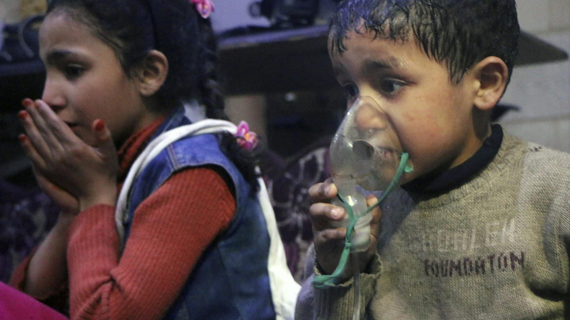 Dieses vom Syrischen Zivilschutz, genannt "Weißhelme", zur Verfügung gestellte Bild zeigt einen Junge, der ein Beatmungsgerät über den Mund hält: Nach Angaben der Weißhelme hatte ein Hubschrauber eine Fassbombe mit Chemikalien über der Stadt Duma abgeworfen.