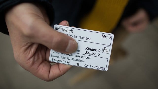Ein Mann zeigt seine Berechtigungskarte vor dem Eingang zur Essener Tafel: Die Hilfsorganisation hatte seit dem 10. Ein Mann zeigt seine Berechtigungskarte vor dem Eingang zur Essener Tafel: Die Hilfsorganisation hatte seit dem 10.