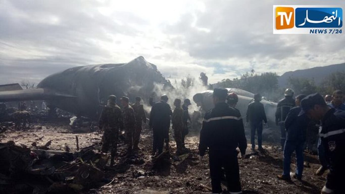 Feuerwehrleute vor dem Wrack des abgestürzten Militärflugzeugs.