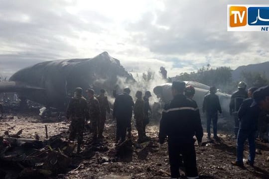 Feuerwehrleute vor dem Wrack des abgestürzten Militärflugzeugs.