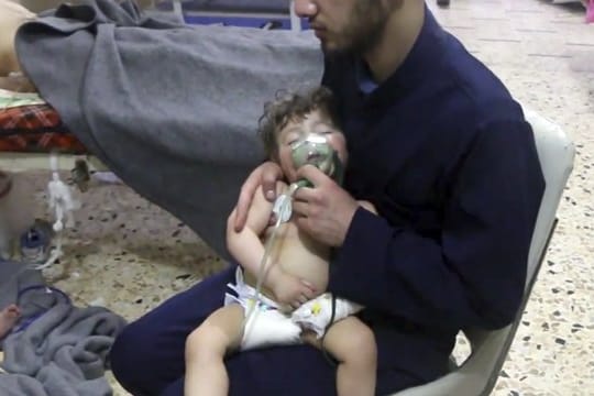 Dieses vom Syrischen Zivilschutz zur Verfügung gestellte Videostandbild zeigt einen Sanitäter, der ein Kleinkind medizinisch versorgt.