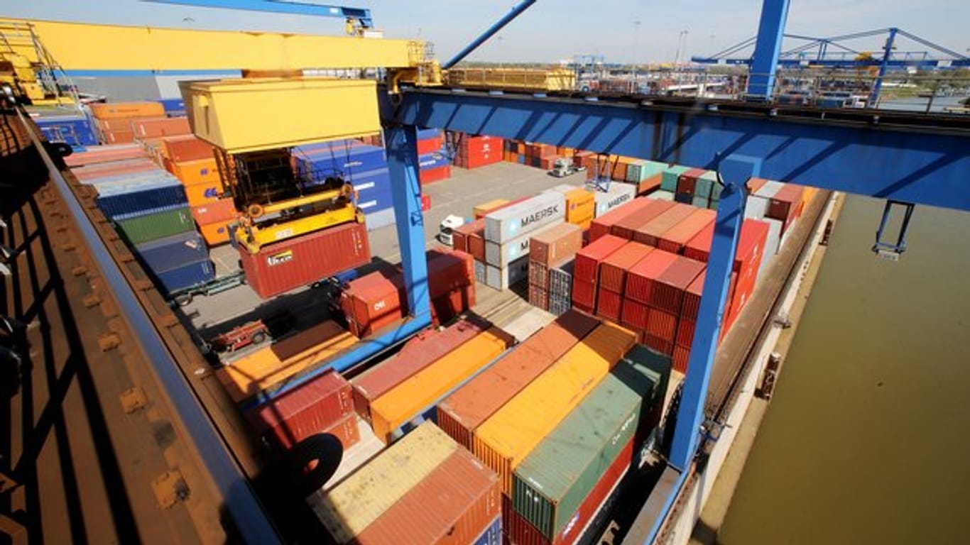 Container werden von einem Kran auf die richtigen Positionen gebracht.