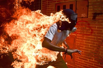 Ronaldo Schemidts Foto "Venezuela Krise" ist das "World Press Photo" 2018: Der junge Mann unter der Gasmaske hat mit Verbrennungen überlebt.