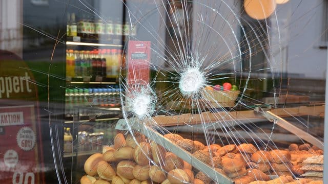 Nach dem Polizeieinsatz: Einschlagstellen in der Scheibe der Bäckerei, vor der ein randalierender Mann mehrere Menschen angegriffen hatte. Nach dem Polizeieinsatz: Einschlagstellen in der Scheibe der Bäckerei, vor der ein randalierender Mann mehrere Menschen angegriffen hatte.