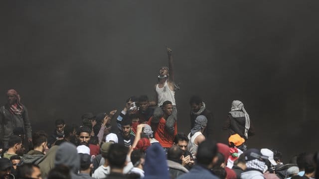 Schwarze Wand im Gazastreifen: Vor dem Hintergrund brennender Autoreifen protestieren Palästinenser an der Grenze zu Israel. Schwarze Wand im Gazastreifen: Vor dem Hintergrund brennender Autoreifen protestieren Palästinenser an der Grenze zu Israel.