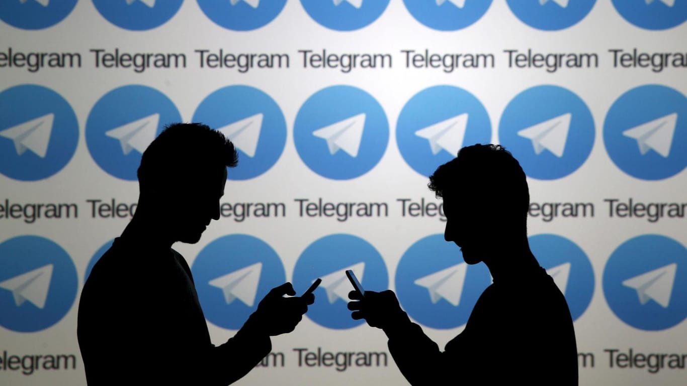Smartphone-Nutzer vor Telegram-Logos: Sperrung per Gerichtsbeschluss
