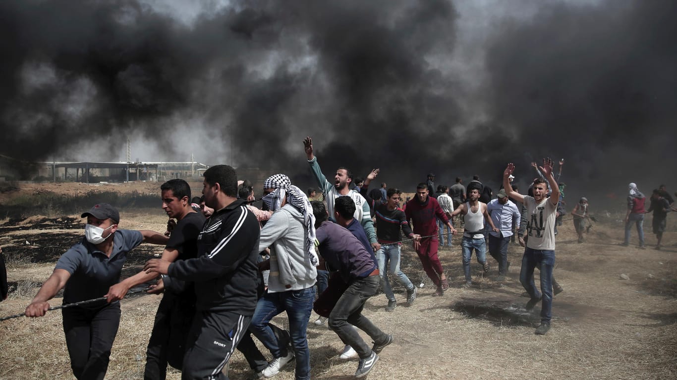 Palästinenser bei den Demonstrationen in Gaza, im Hintergrund sieht man die Verwüstung: Bei den Protesten der Hamas greifen Sicherheitskräfte zu Schusswaffen und Tränengas. 363 Menschen wurden verletzt.
