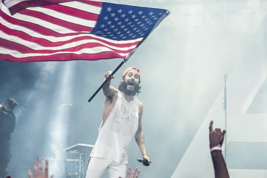 Jared Leto von der Band Thirty Seconds To Mars schwenkt die US-Flagge.