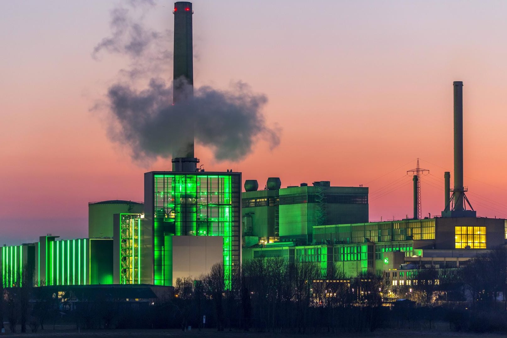 Das Heizkraftwerk Lausward in Düsseldorf, Gas- und Dampfturbinenkraftwerk, betrieben von den Stadtwerken Düsseldorf und EnBW, im Hafen von Düsseldorf am Rhein, grün beleuchtetes Stadtfenster, der Kamin des Krafwerksblock Fortuna, das Kraftwerk erzeugt Strom, auch Bahnstrom und Fernwärme,