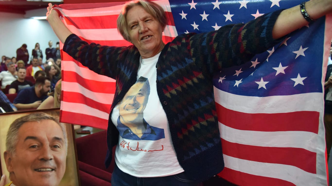 Eine Sympathisantin von Milo Djukanovic mit einer Flagge der USA freut sich über seine Wiederwahl: Djukanovic wurde wiedergewählt, er bleibt für die USA und die EU einer der wichtigsten Ansprechspartner.