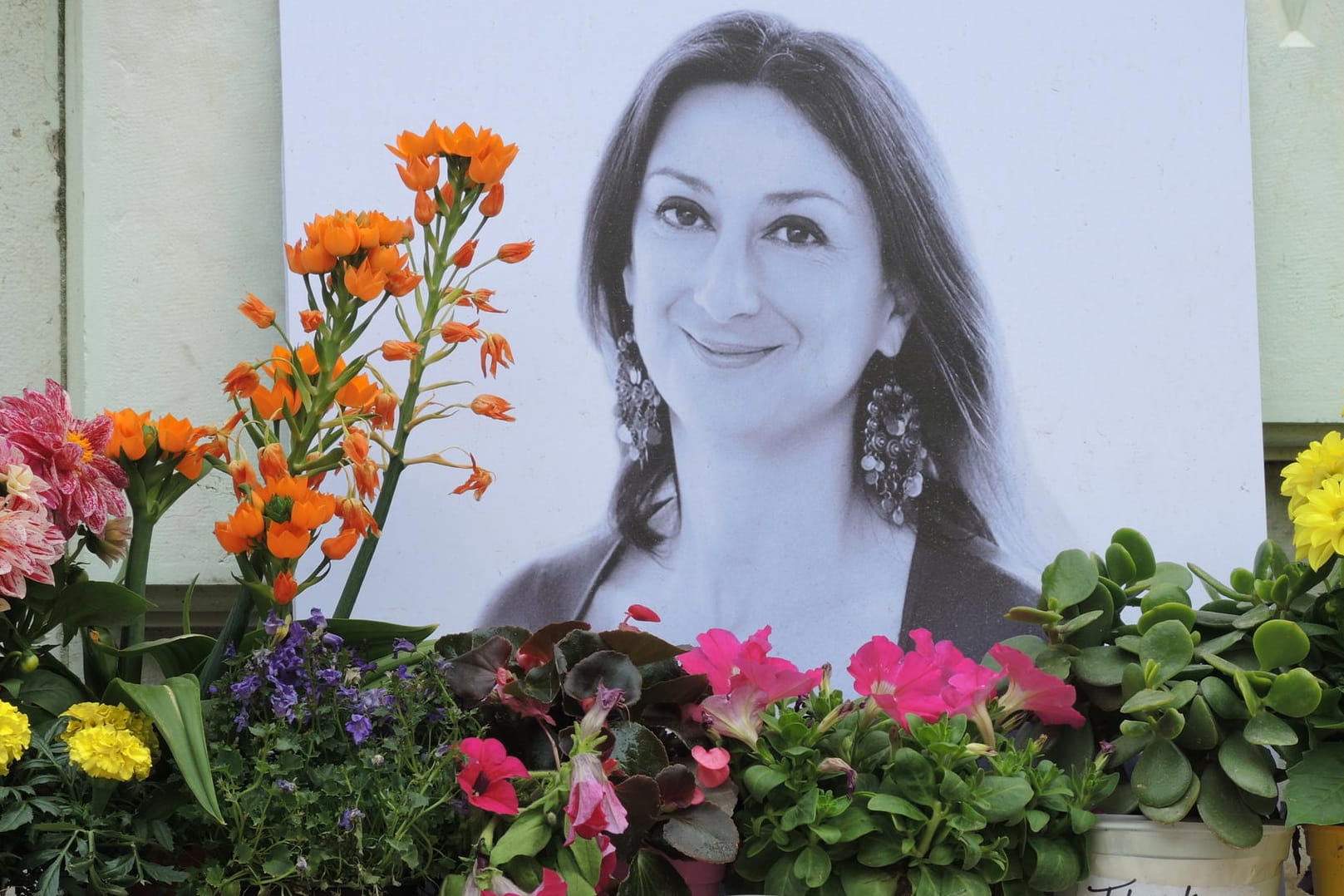 Am Fuß eines Denkmals vor dem Justizpalast in Valletta (Malta) erinnert ein Foto an die ermordete Journalistin Daphne Caruana Galizi:. Ein halbes Jahr nach dem Attentat kritisieren Schriftsteller die schleppenden Ermittlungen. (Archivbild)