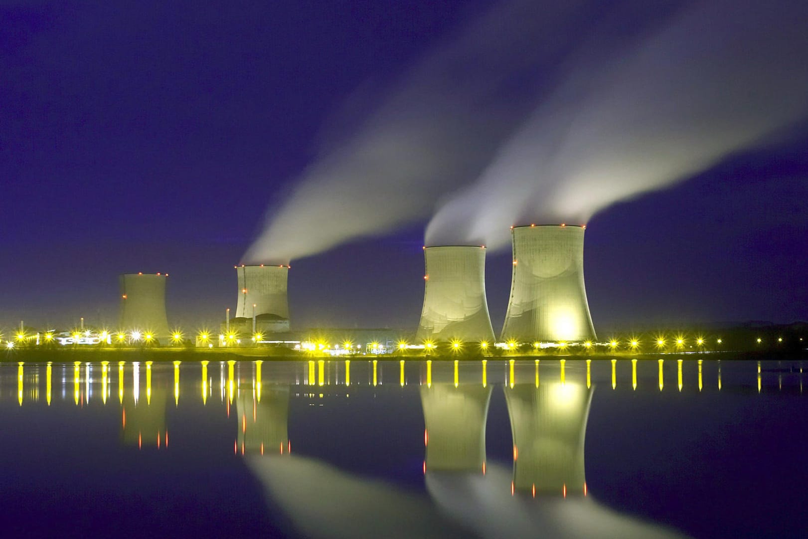Das französische Atomkraftwerk Cattenom nahe der deutschen Grenze spiegelt sich im Wasser des nahegelegenen Sees: Rheinland-Pfalz und Saarland haben sich gegen eine Klage gegen das französische Atomkraftwerk entschieden. (Archivbild)