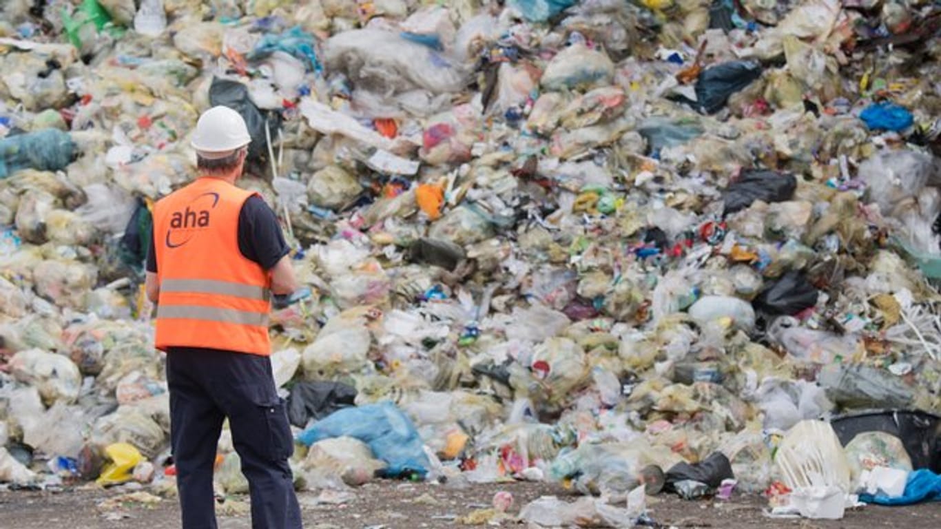 Ein Mitarbeiter einer Deponie vor einem Müllberg: In der Gelben Tonne landet oft Müll, der dort gar nicht hingehört.