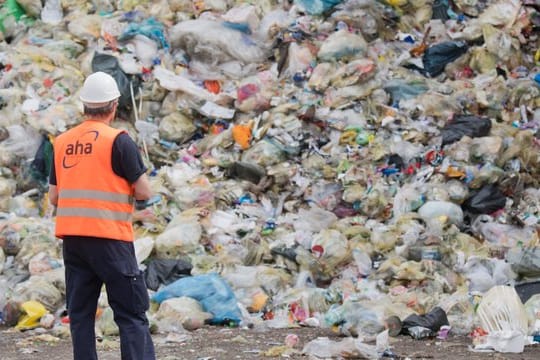 Ein Mitarbeiter einer Deponie vor einem Müllberg: In der Gelben Tonne landet oft Müll, der dort gar nicht hingehört.