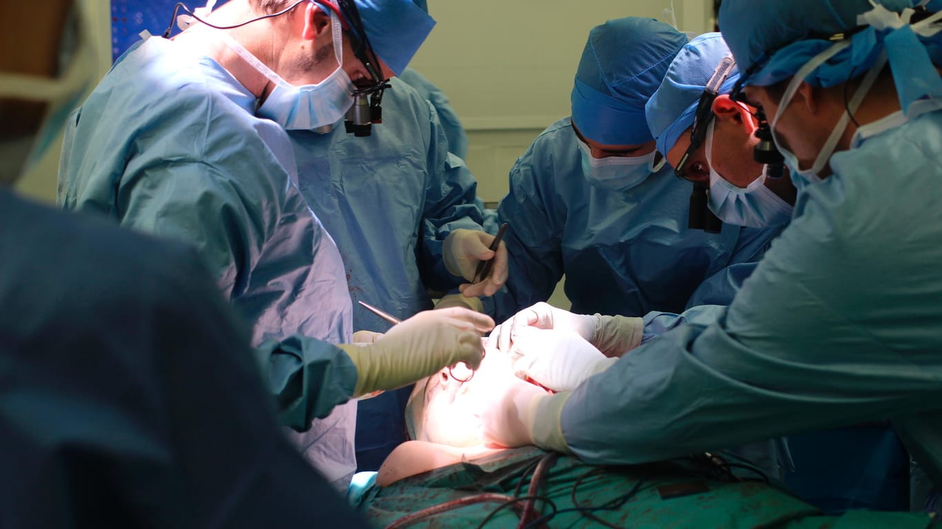 Ärzte und Schwester des Pariser George-Pompidou-Krankenhauses bei einer Gesichtstransplantation: Als erster Mensch der Welt überlebte ein 43-jähriger Franzose zwei Gesichtstransplantationen.